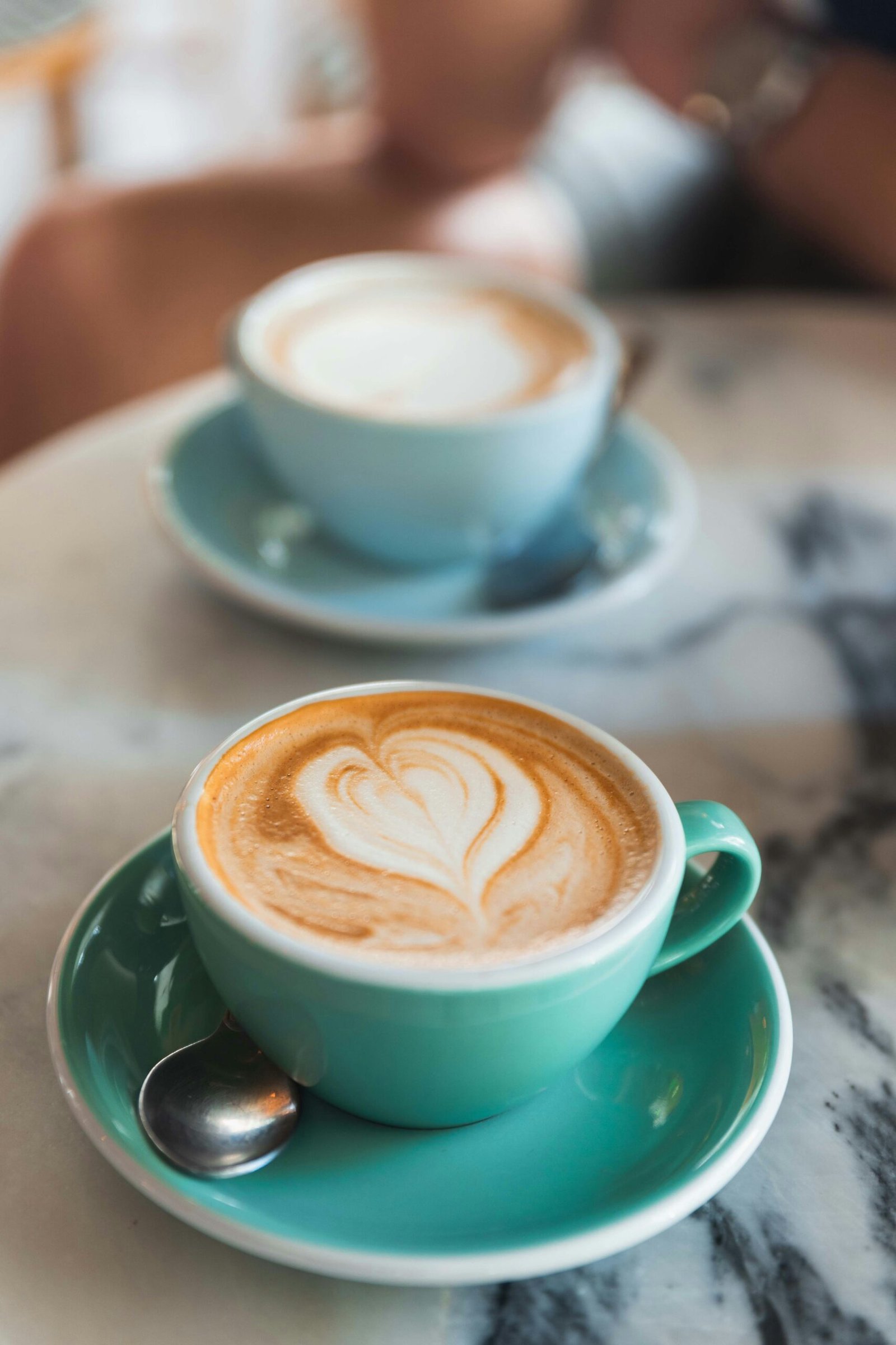 Best Coffee Shops in Greenwich Village In a coffee shop, on a coffee table, two green cups of coffee