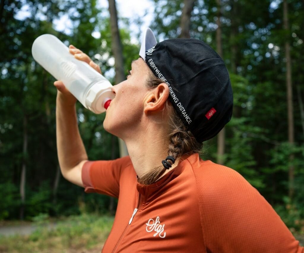 a woman drinking water to fill gallon necessities for 5 hard challenge