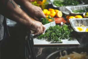75 hard meal prep: a man is cutting vegetables to prepare meals.
